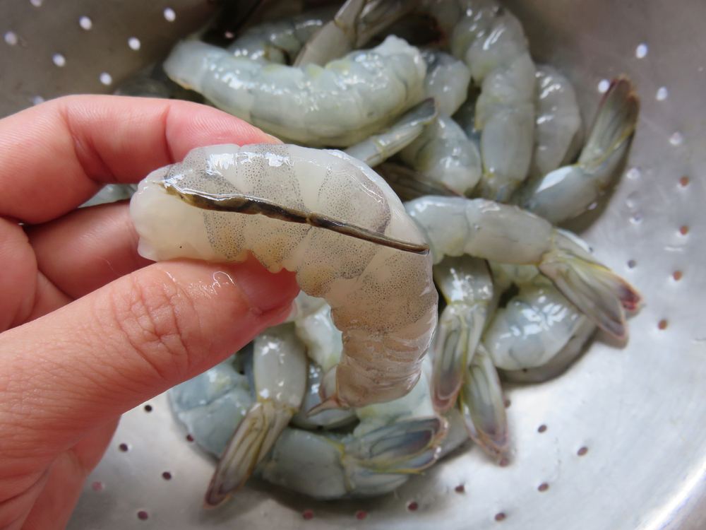 Mit dem Messer entlang des Garnelenrückens einen Schnitt machen, um die schwarze Linie, den Darm, vor dem Kochen zu entfernen. Garnelen können für Salate, Scampi oder Spieße verwendet werden.